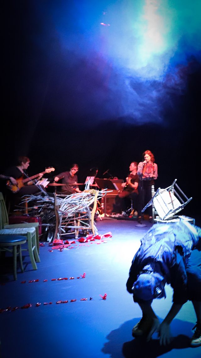 Bower bird dancer folded at the waist, Julie and the band in the background