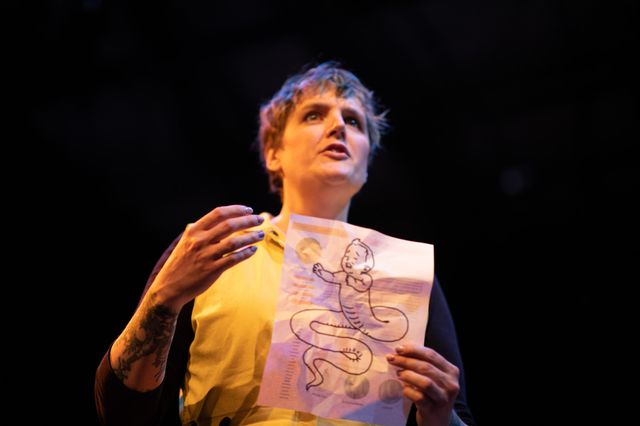 Miriam holds a crumpled paper with a drawing of a serpent child